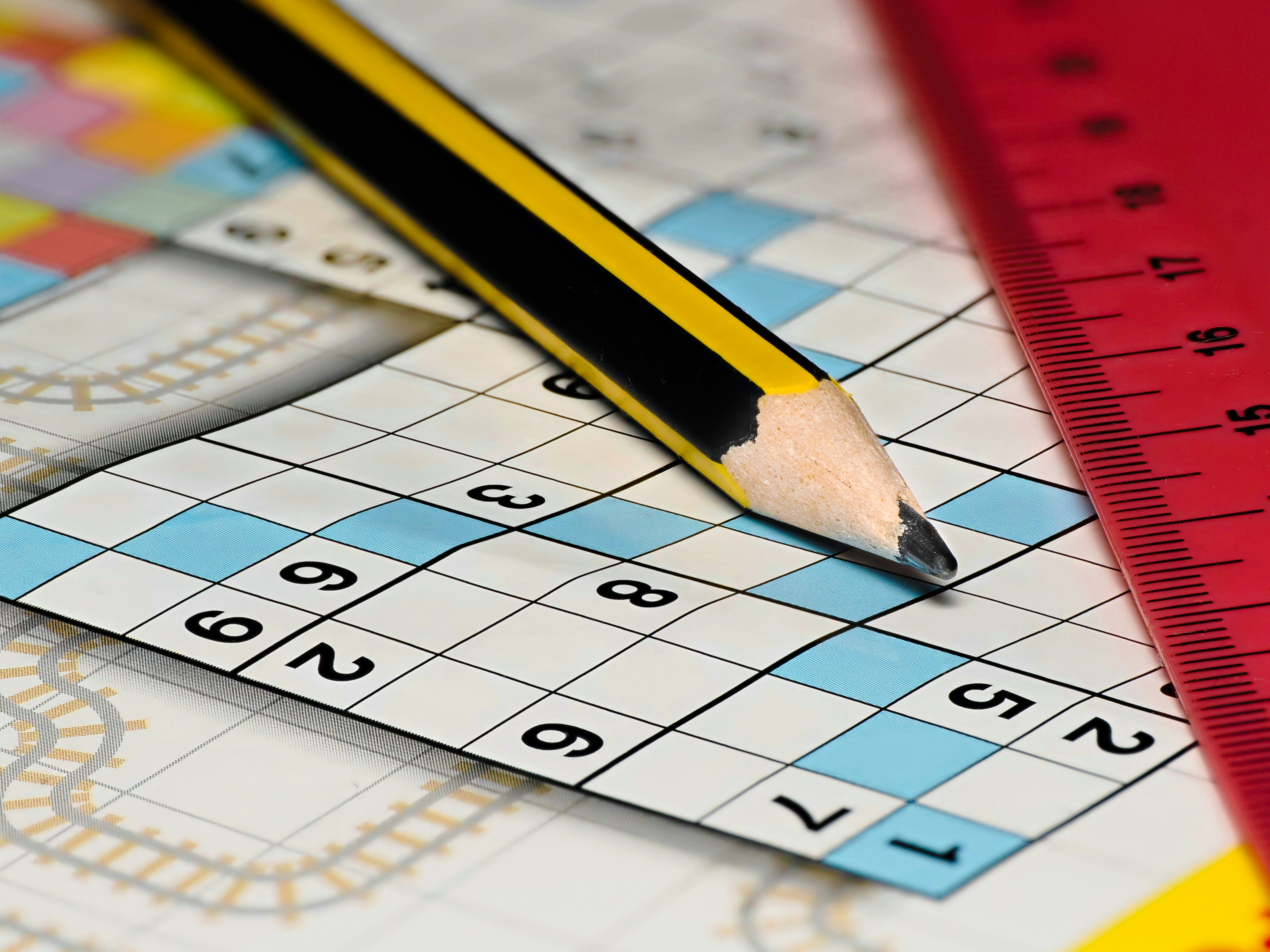 pencil and ruler on a crossword book